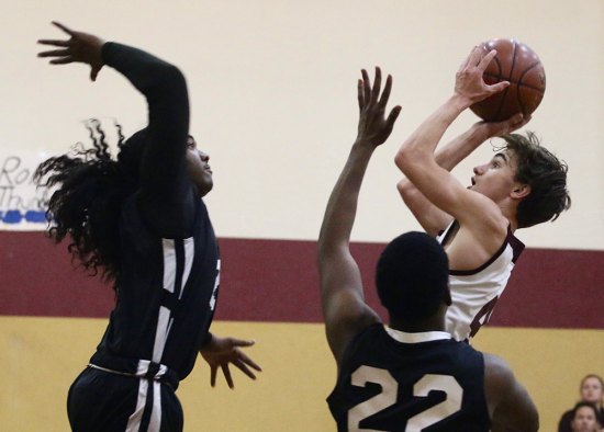 Kings Christian's Hunter Naftzger shoots over a California City defender during Tuesday night's home basketball contest. 